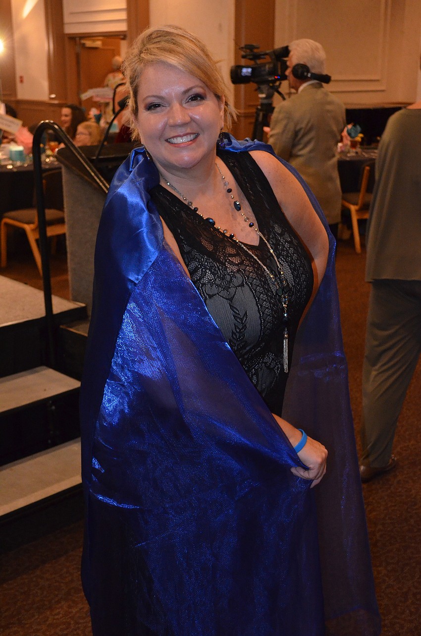 Vice President of Goodwill Manasota Veronica Brandon Miller sporting a Goodwill cape as her pop of color.