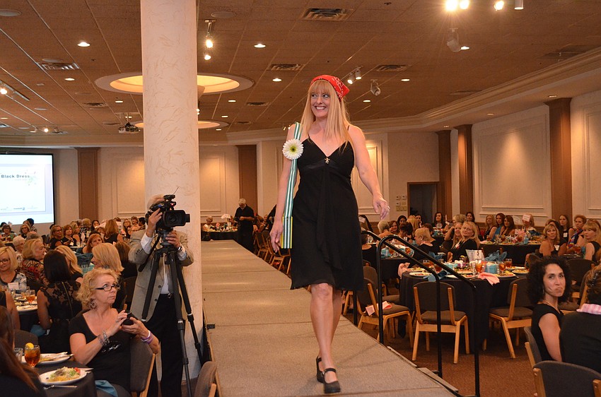 Junior League model Keri Kuhn hits the runway in a Goodwill dress and bag made from a recycled Girl Scout cookie box.