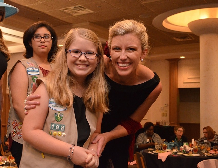 Britt Riner poses on the runway with Girl Scout Allison Carchio. Riner wore a dress from J.R. Nites by Caliendo that costs $6.99 from Goodwill.