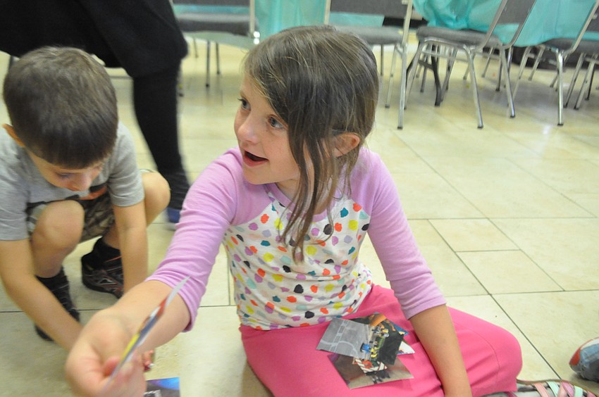 Yocheved Schmerling, 6, shows her friends one of the pictures she glues to a poster board.