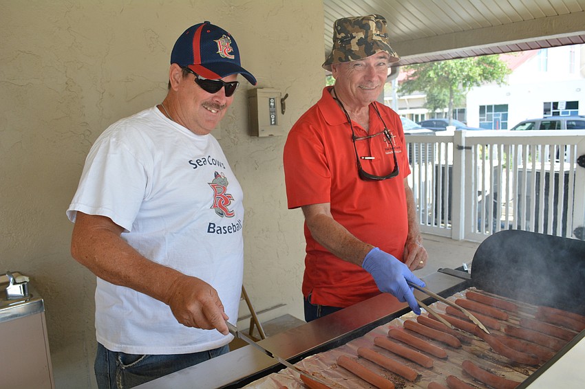 Ron Gardner and Bruce Andrews cook hot dogs for the post-game family picnic.
