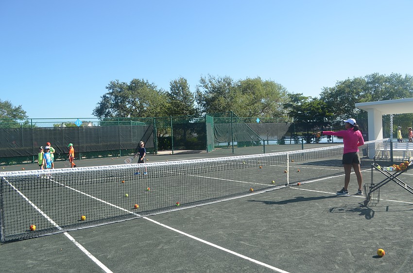 Tennis Camp Director Briana Francois instructs campers before beginning a new game.