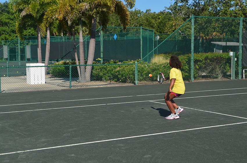 Shama Green, 9, hits the ball during tennis camp at the Longboat Key Club.