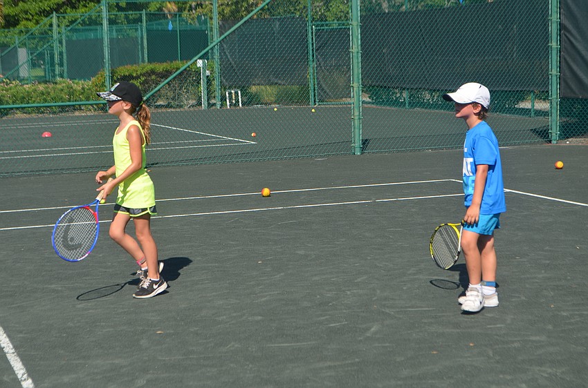 Nina Tahar, 9, with her brother, Roman, 7, wait to start a new activity.