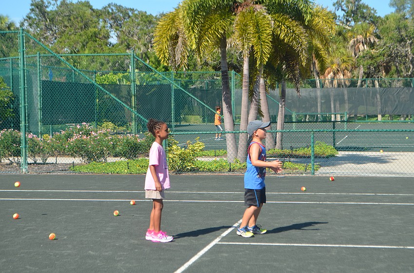 Selina Green, 6, and Dylan McLeod, 6, try to catch tennis balls during a game of “jail.”