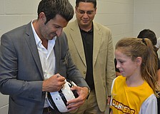 Luis Figo signs a ball for Lakewood Ranch's Brinley Beorlegui on her 10th birthday. Carlos Vallejo, who will be Figo's tournament director when it comes to Lakewood Ranch in November, watches.
