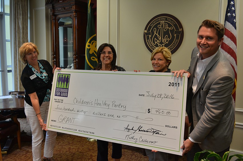 Bart Lowther, right, accepts a grant on behalf of Children's Healthy Pantry with the help of Sisterhood for Good members Kathy Collums, Lori Ruth and Angela Massaro-Fain.