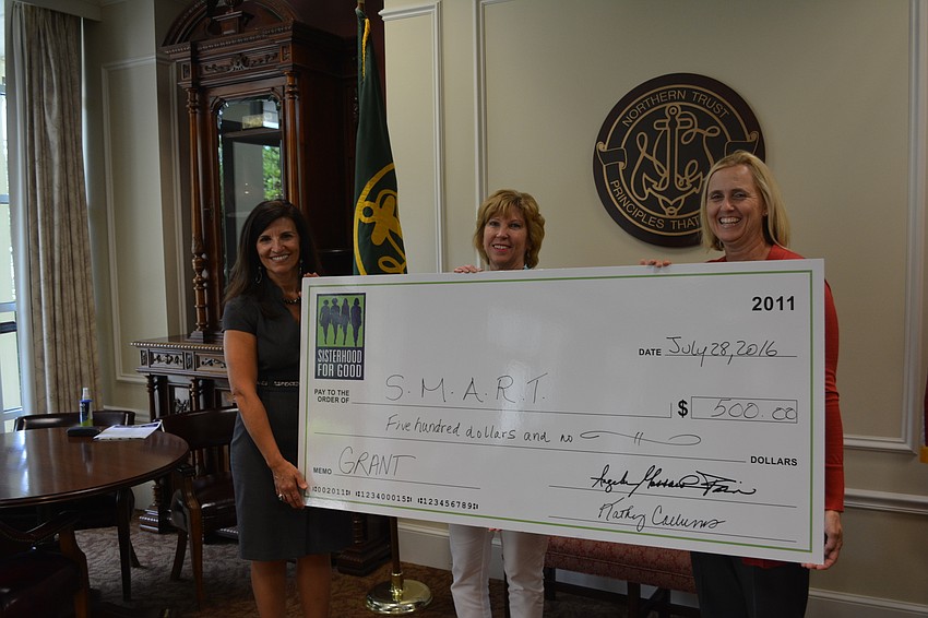 Sisterhood for Good's Violeta Huesman and Kathy Collums present a check to Jenifer Schembri of Sarasota Manatee Association for Riding Therapy.