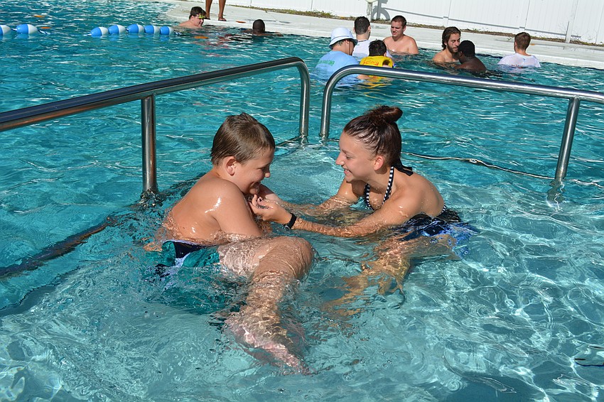 Colby Missineo, 11, laughs as he is tickled by counselor Gabby Reinke.