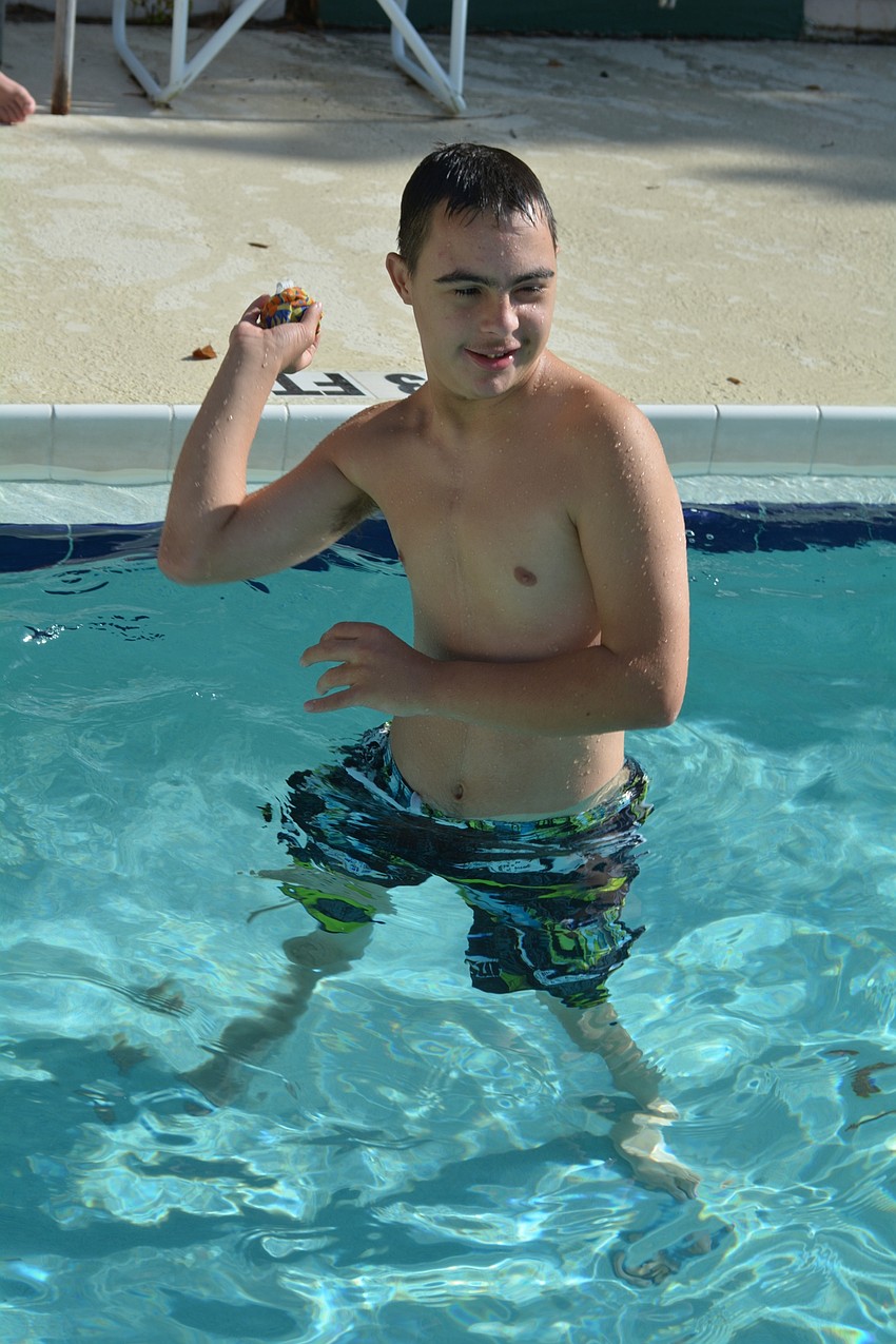 Payton Aaron, 15, plays a game of catch with friends in the pool.