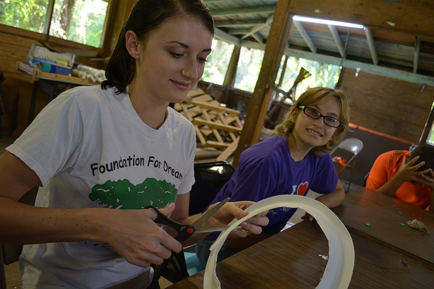 Maya McCarthy helps camper Tressa Pringle, 14, with her 