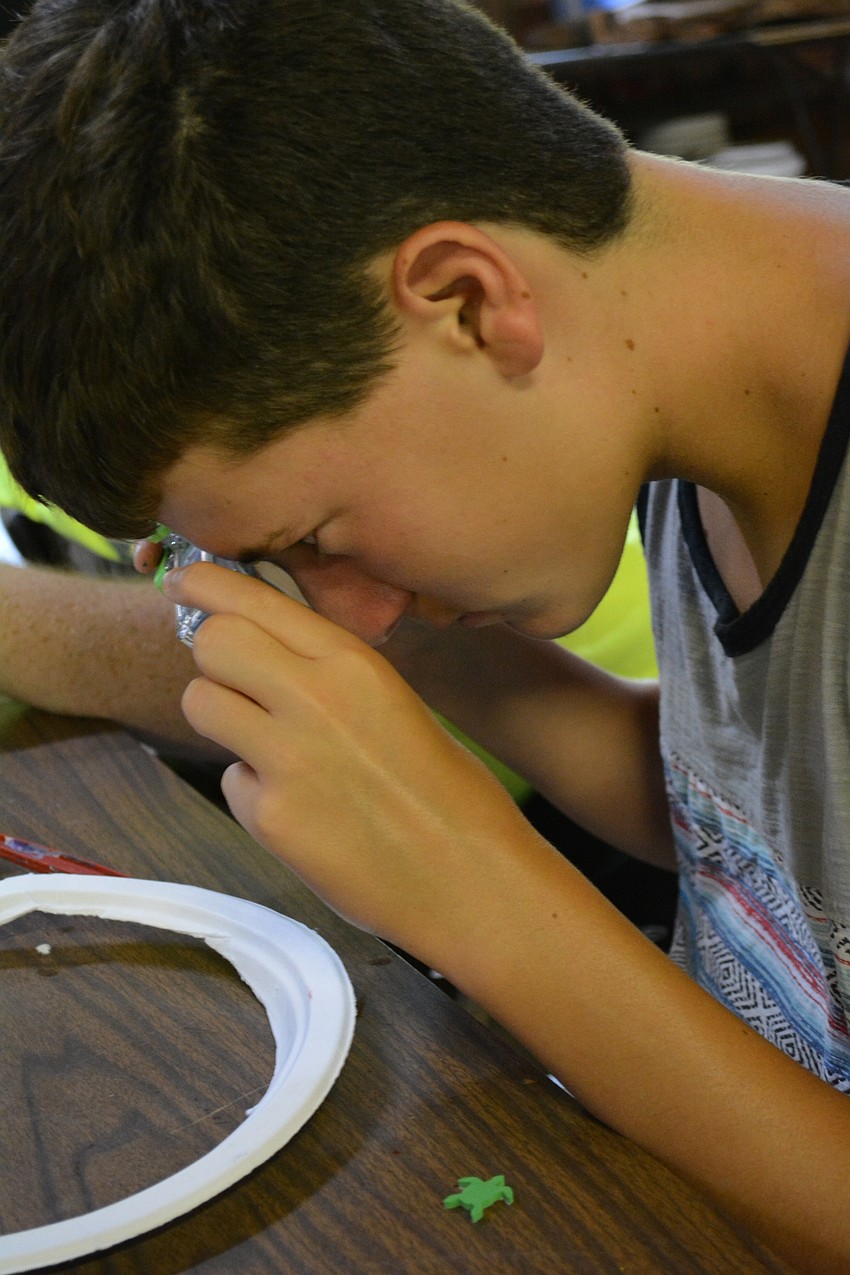 Camper Aidan Smith takes a photograph of his craft with his underwater camera. He was very excited about his date to the dance with counselor Rachel Levy.