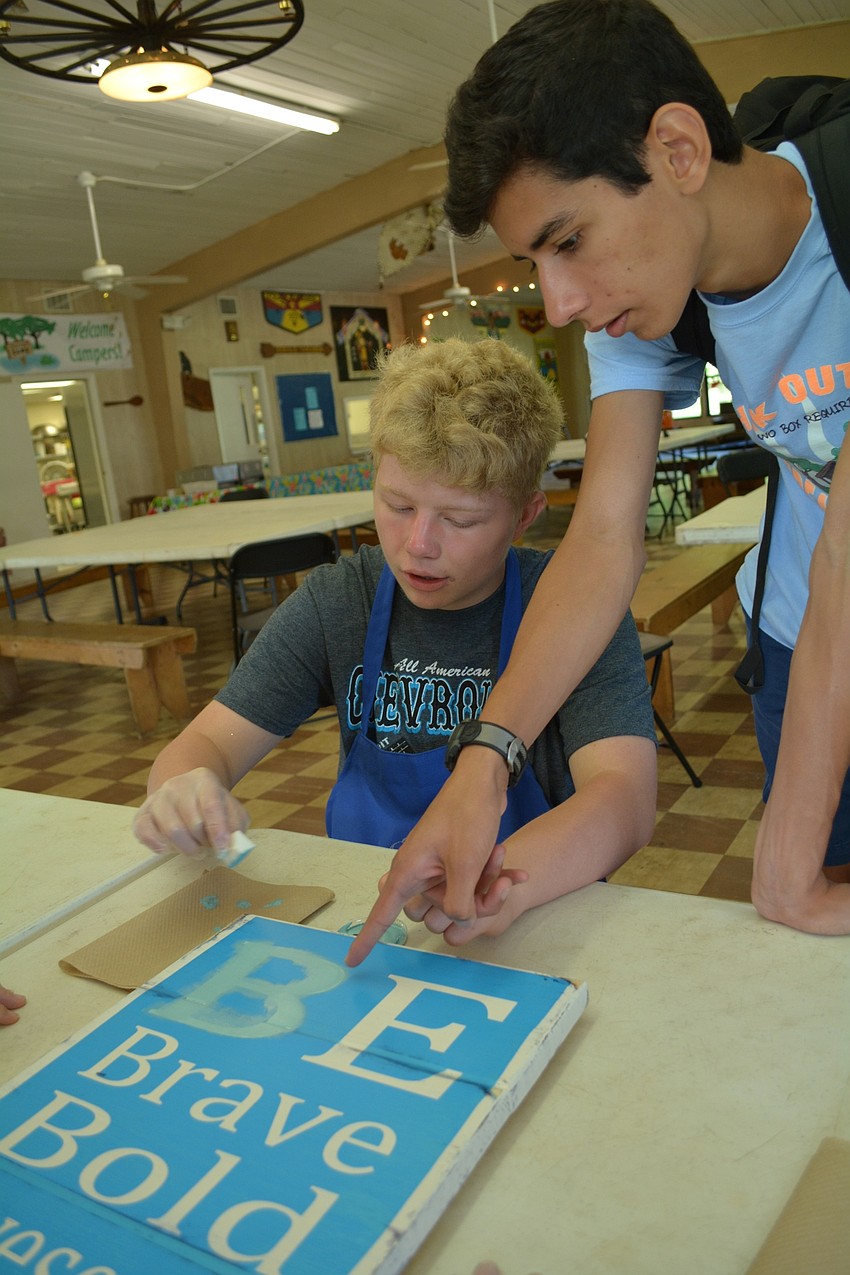 Aric Dutting, 14, a student at Haile Middle School, gets help from Braden River High's Michael Medina with making a do-it-yourself project for the auction fundraiser.