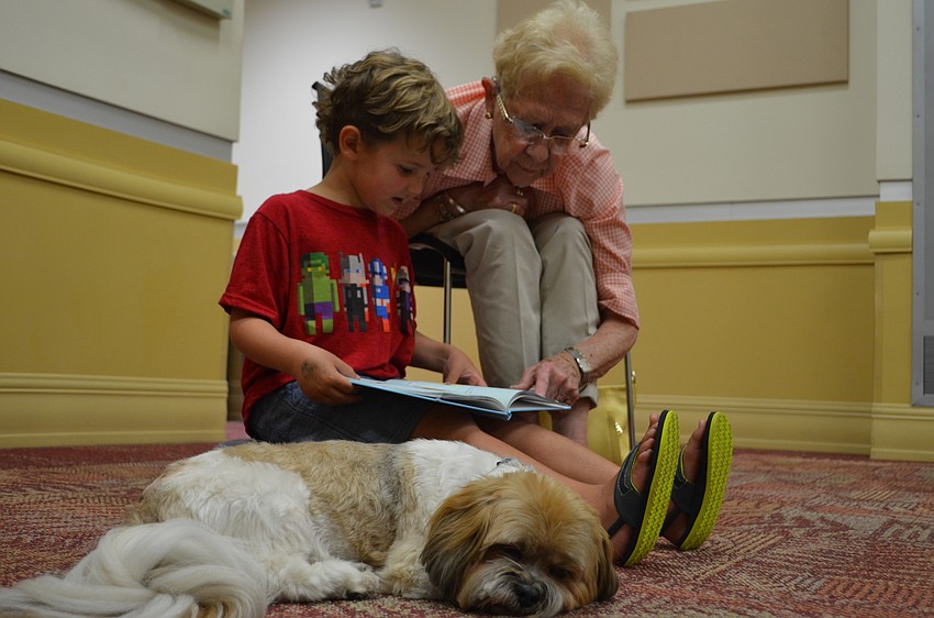 Parker rests his eyes as he is read to by Easton Lopez with assistance by Macie McGee.