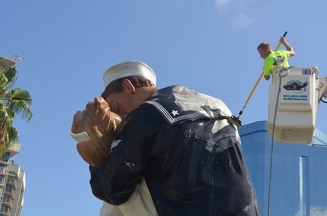 A Gorilla Kleen employee works to clean the Unconditional Surrender statue on Sarasota's bayfront.