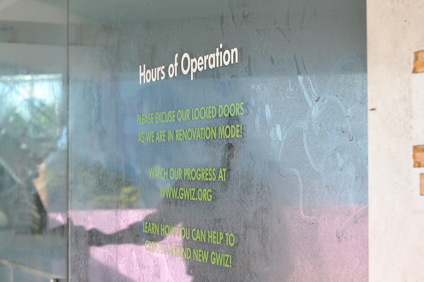 The former hours of operation remain posted at the entrance to the building.