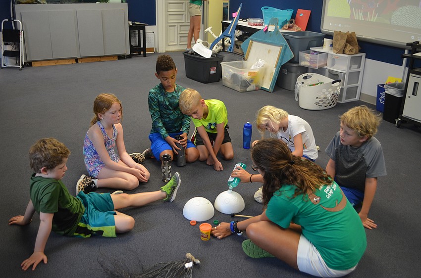 Mote employee Rainia Lardas demonstrates a coral reef activity for her campers.