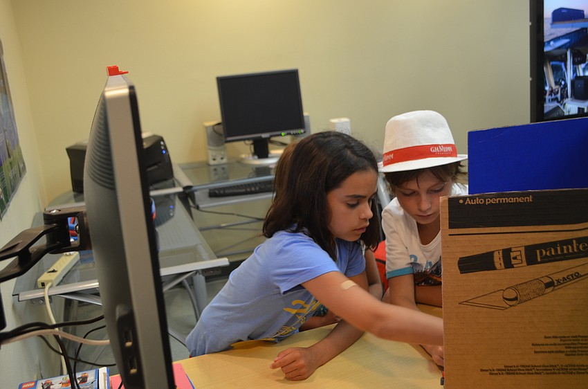 Callahan Hernandez, 10, and Leonardo Susini, 10, maneuver their Lego pieces before re-shooting their video.