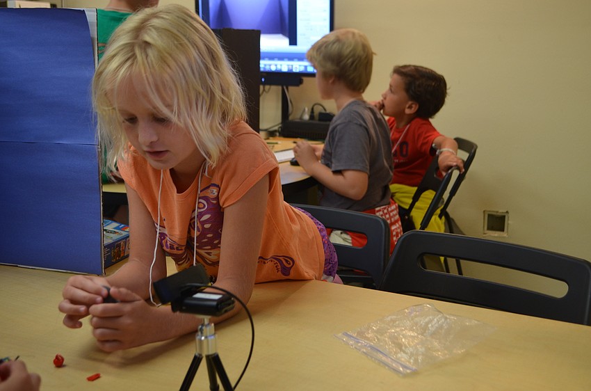 Marin Walters, 8, moves her Lego pieces before taking pictures.