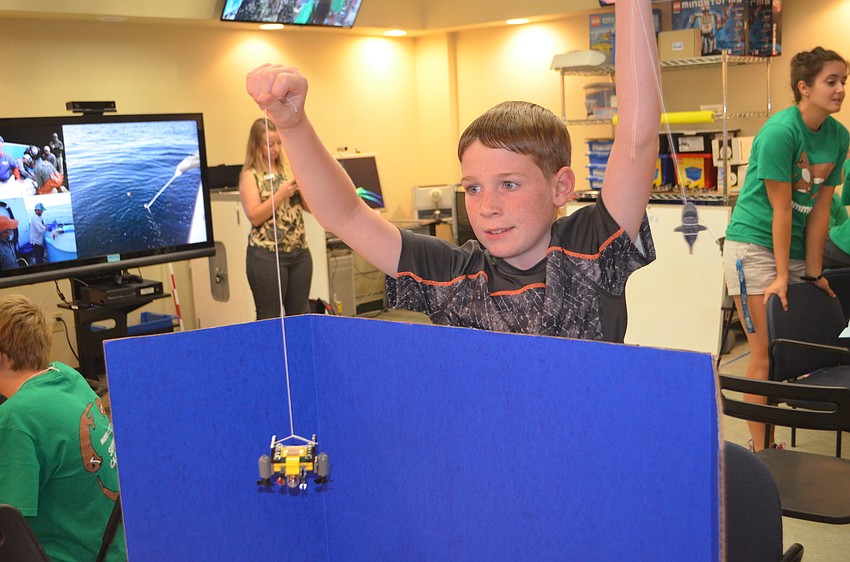 Xander Oleksak, 9, holds his Lego pieces while his partner takes photos.