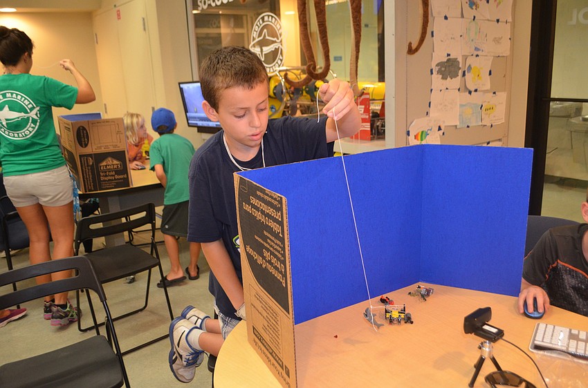 Sebastian Brochu, 10, moves his Lego pieces with a string to create different images for his stop motion video.