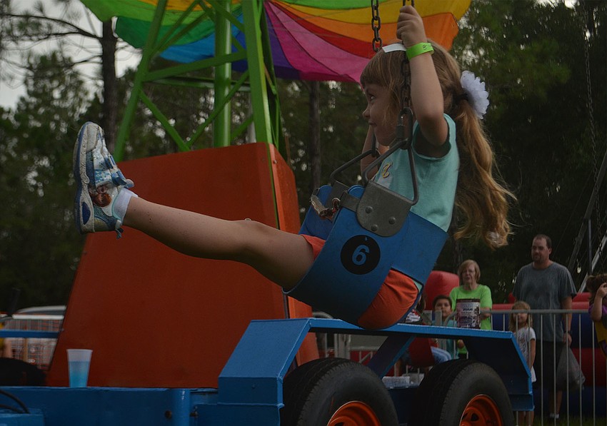 Cassidy Butler, 5, swings her legs back and forth while waiting for the ride to begin.  She was on the ride with her new friend, Jocelyn Gomez (not pictured). The pair met during their first week of school at Dunn Preparatory School just last week.