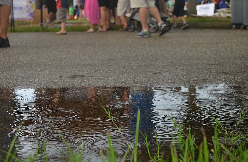 Rain falls as volunteers greet parents and children wait at Woodland Community Church's Back to School Bash. Executive Pastor Dewayne McFarlin has already started planning for next years bash. He's just hoping for better weather.