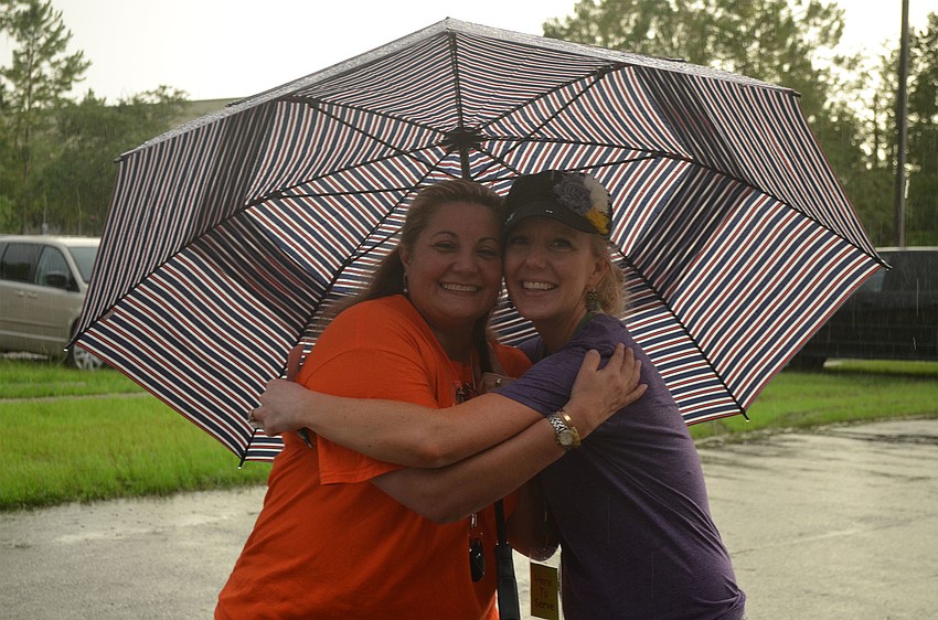 Woodland Community Church Children's Ministry Director, Jennifer Freeman poses with Nina Van Delen under an umbrella at Woodland Community Church's Back to School Bash.