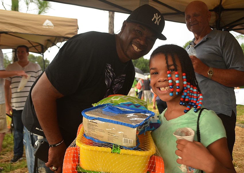 Saniya Swilley, 8, smiles with Bishop Freeze of Sozo Missions. Bishop Freeze brought 33 children to the even Friday evening, including Saniya Swilley, who won a prize during the raffle.