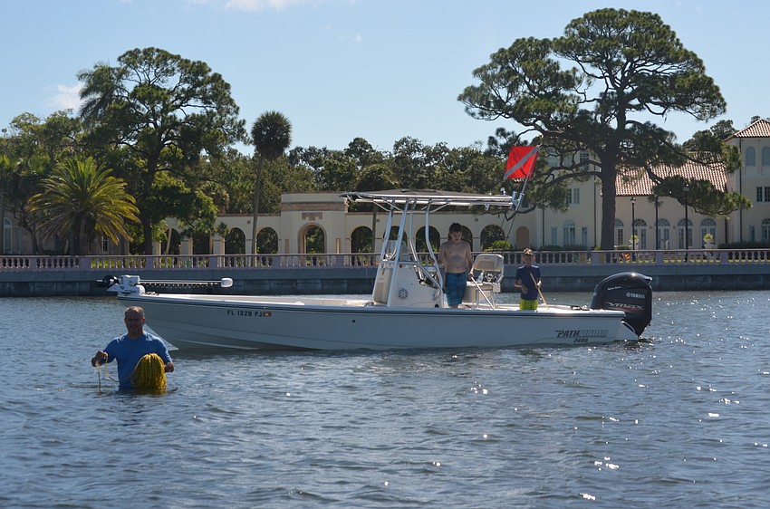 Todd Morton gets ready to move searching spots while his sons help from the boat.