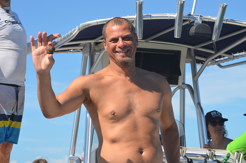 Rene Janneman holds a scallop he found while searching the bay.