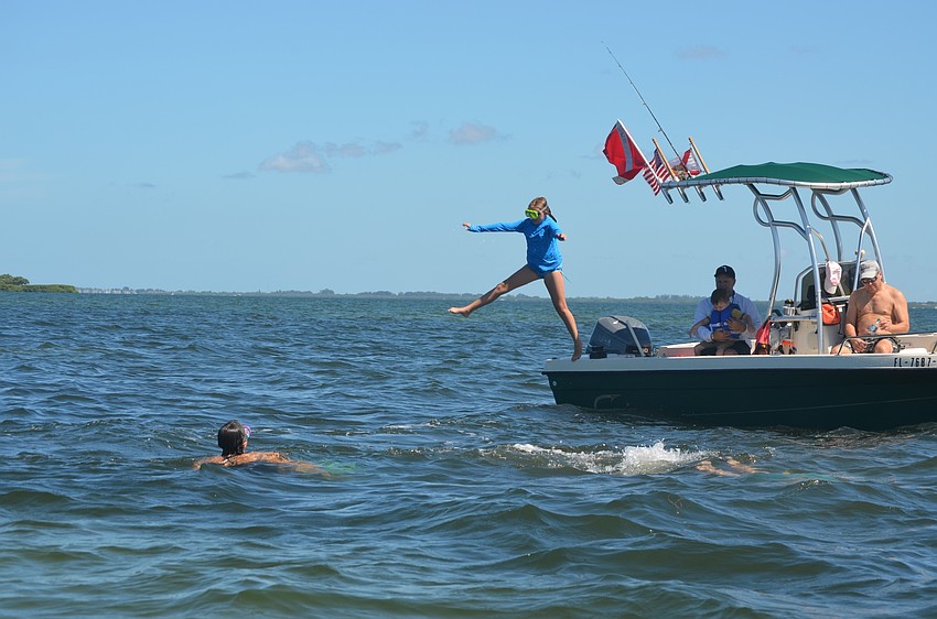 Taylor Stice, 10, jumps off the boat during the annual scallop search.