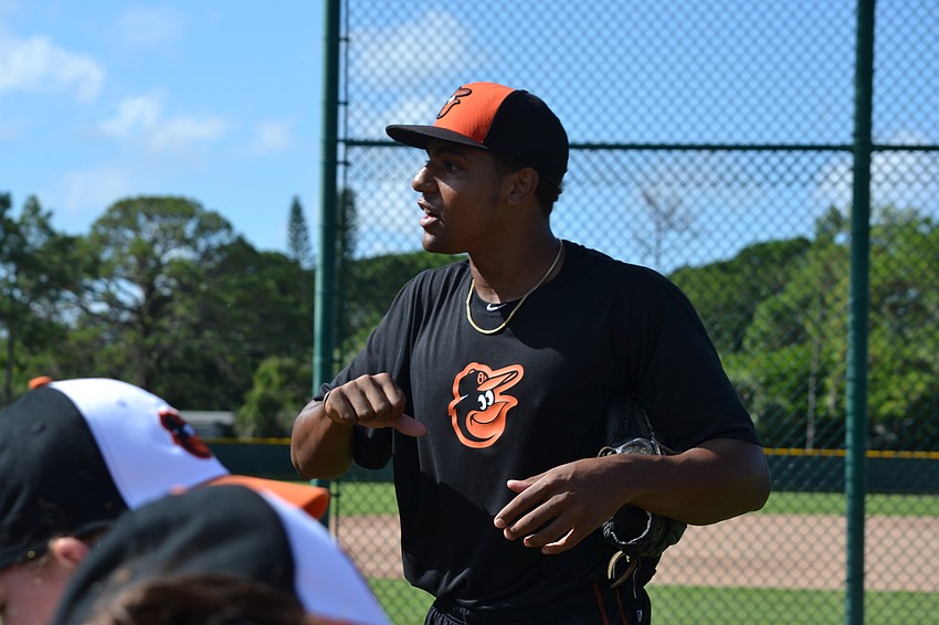 Baltimore Orioles pitcher Brandon Bonilla explains how to grip the laces of the baseball before the pitching exercise.