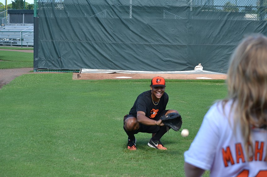 Baltimore Orioles pitcher catches balls during a pitching exercise.