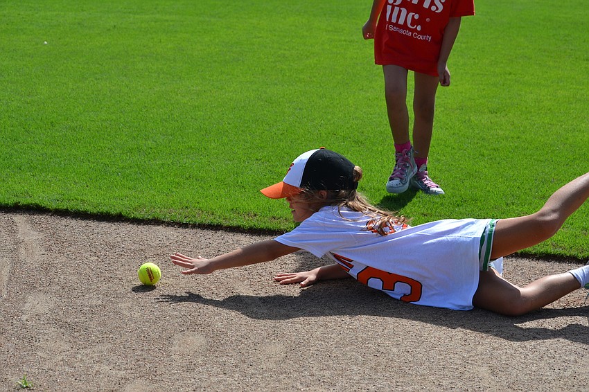 Keira dives for a ball during a hitting and fielding exercise.