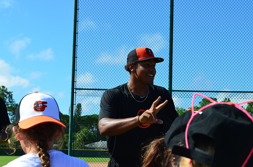 Orioles pitcher Brandon Bonilla explains how to grip the laces of the baseball before the pitching exercise.