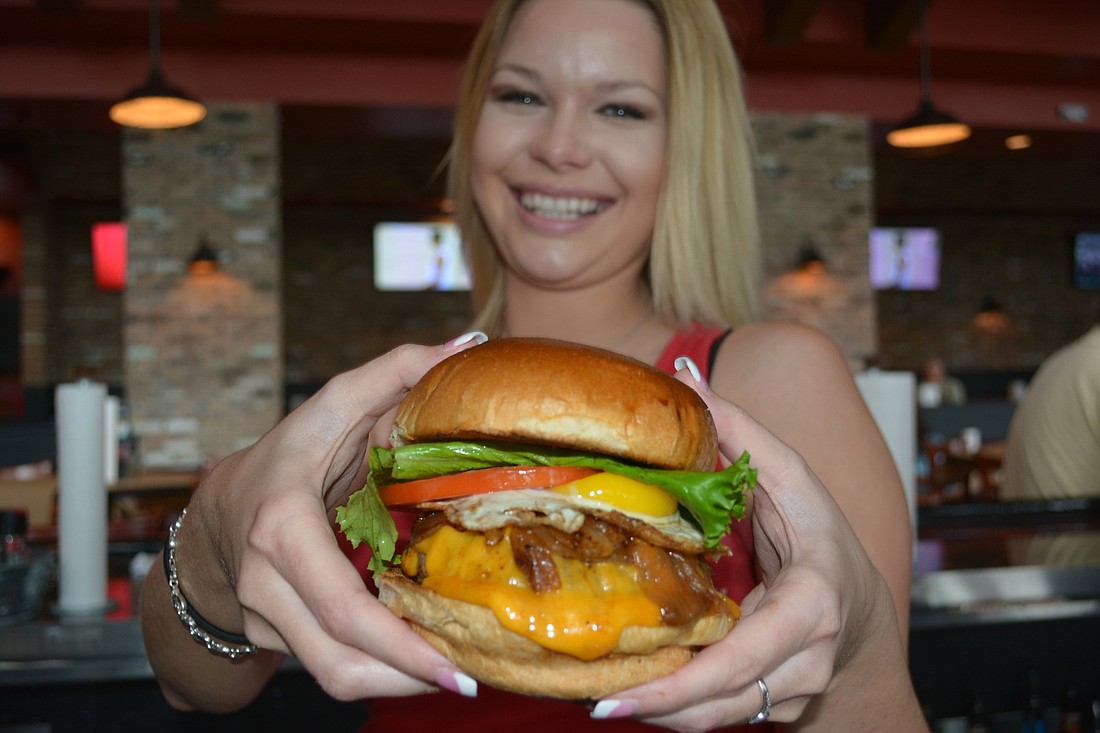 Bartender Danielle Houghton dares you to wrap two hands around a Hotel California burger at Burger & Beer Joint at UTC mall.