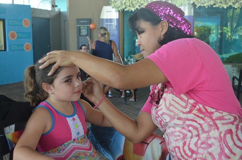 Adrianna Sommer, 7 gets her face painted during the Fins and Fun Family Festival by Akiko the face painter.