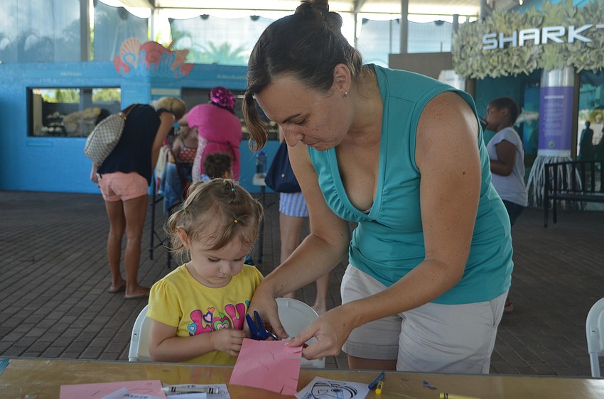 Lydia Myer, 2, cuts out an art project with her mom, Karissa.