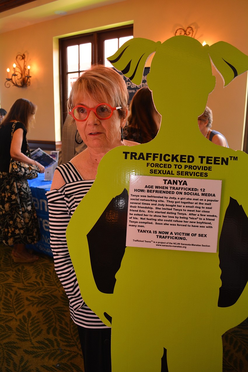 Joan Bour holds a sign and tells passersby: 