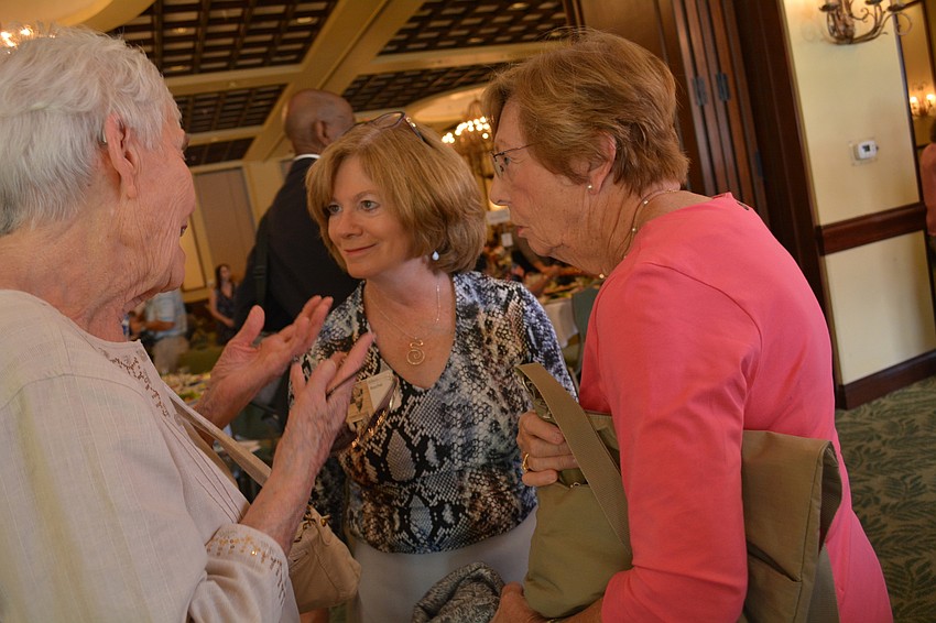 Ellen Roche, center, helps direct guests Betty Schattschneider, left, and Annadele Jackson, right, to the registration table.