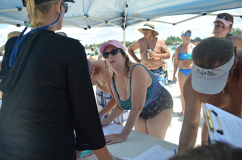 Priscilla Savage fills out a charter amendment petition form to reopen a portion of Beach Road on Siesta Key.