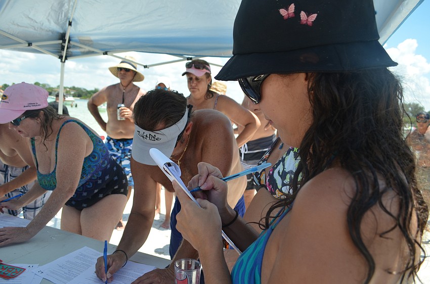 Susy Reis fills out a charter amendment petition form to reopen a portion of Beach Road on Siesta Key.