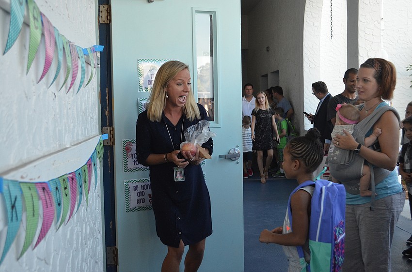 Kindergarten teacher Jeannette Nowaski opens the door to her classroom for eager students to enter.