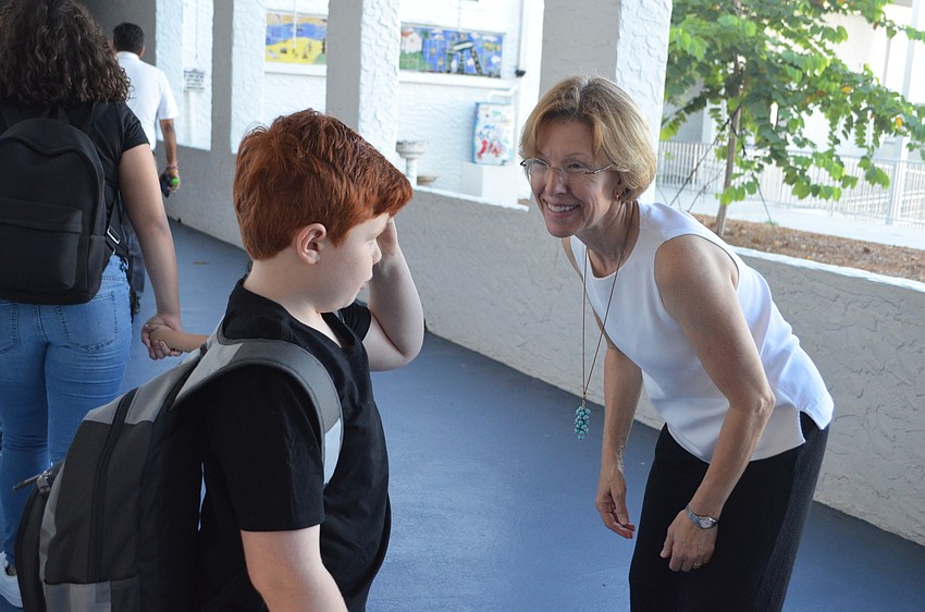 Speech and language teacher Kathy Gold welcomes students to campus at Bay Haven School of Basics Plus.