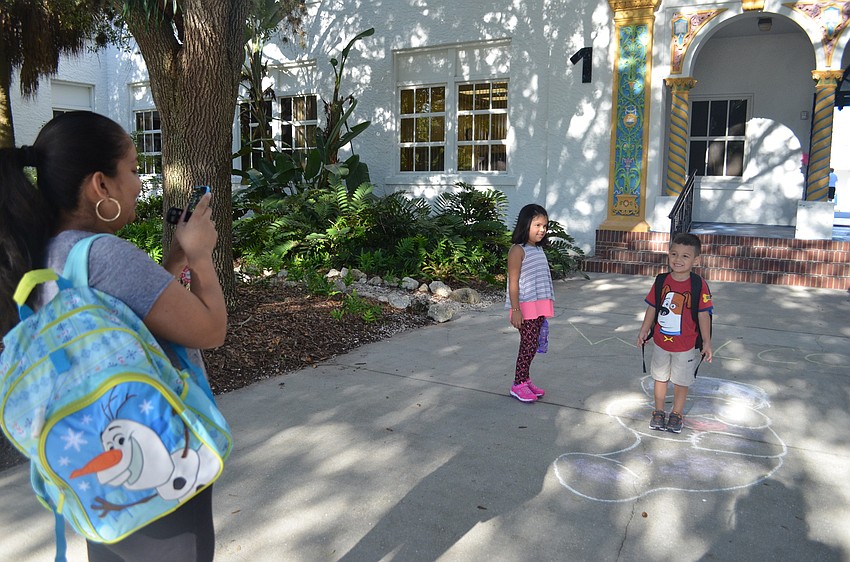 Yajaira Aballua snaps a photo of her son David in front of his new school.