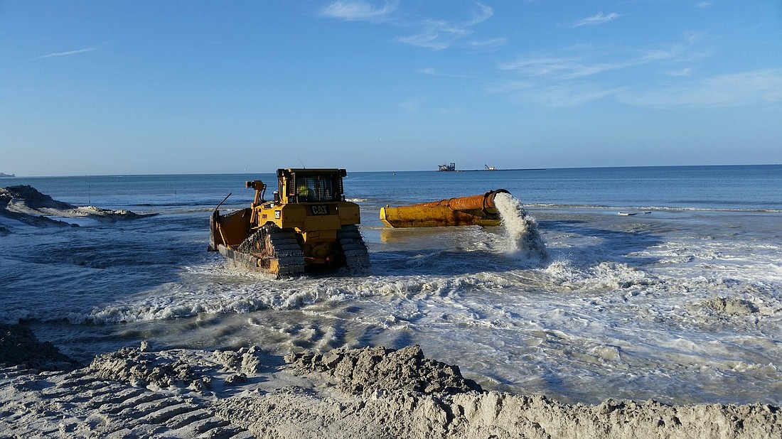 Sand dredging begins to establish a beachhead from which to work using sand dredged from in New Pass.