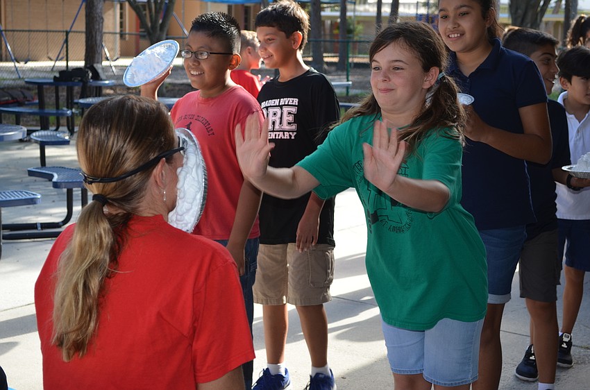 Megan Bovaird throws a pie perfectly at Principal Hayley Rio's face.