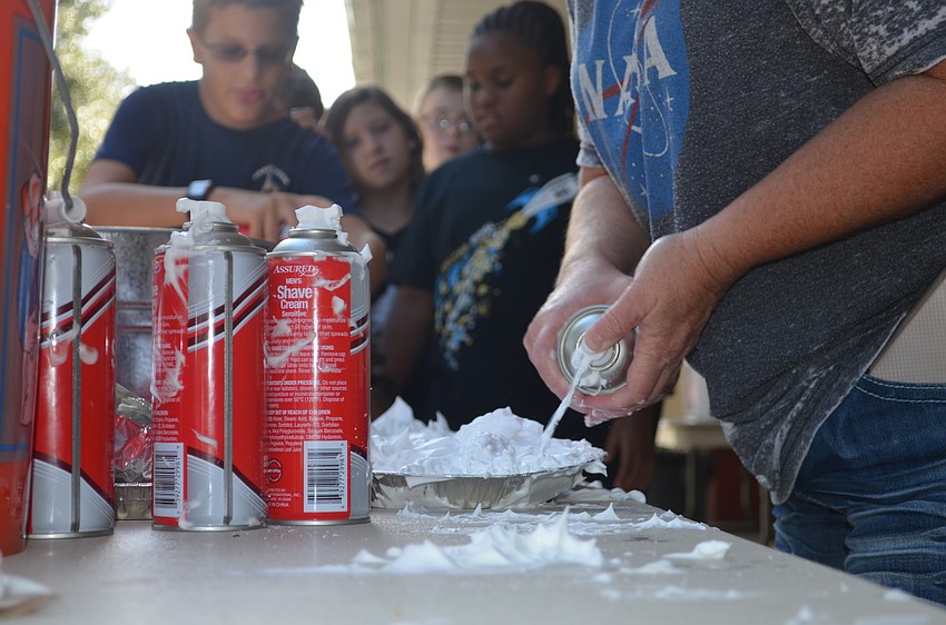 Genny Knopf fills the pie plates with shaving cream for the long line of kids.
