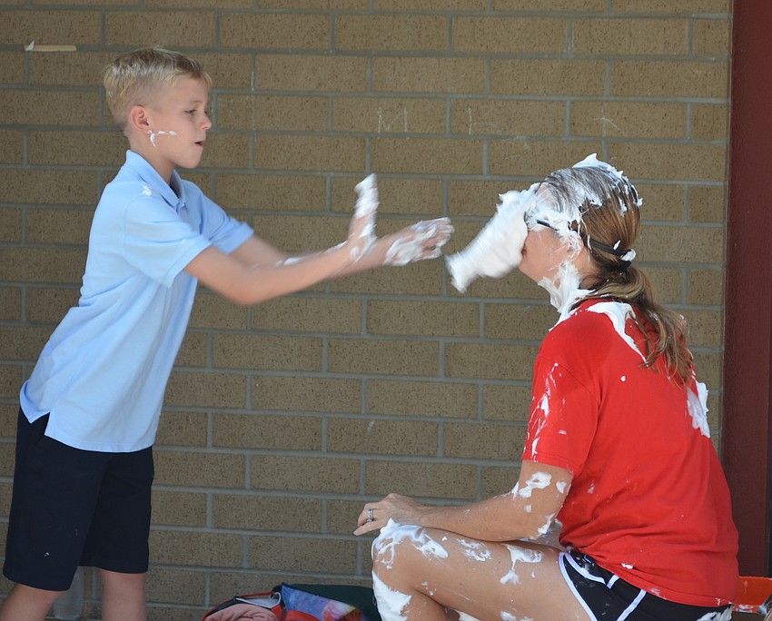 Kyler Wade throws a pie at Principal Hayley Rio.